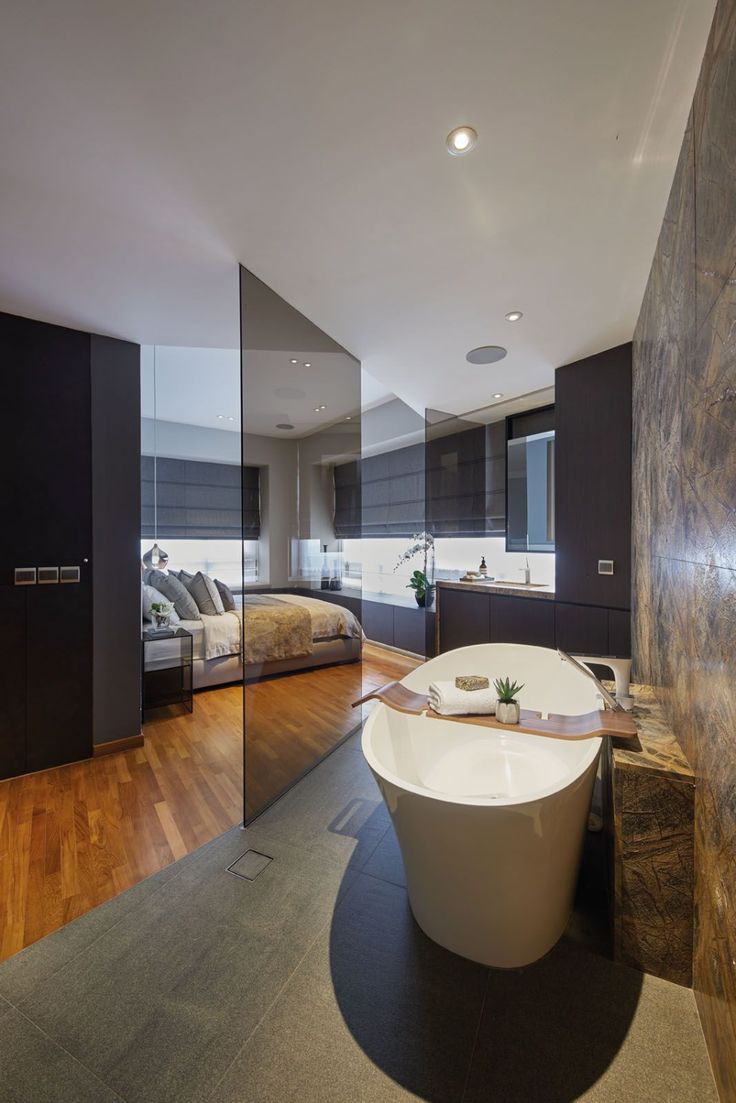 a bathroom with a large bathtub next to a bed in the middle of it