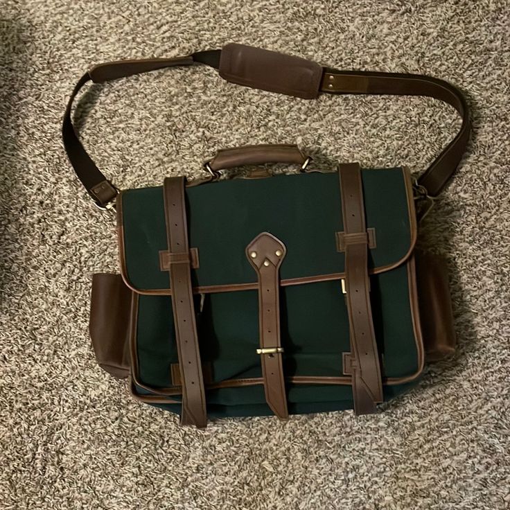 This Is A Green Canvas And Leather Briefcase. Green Vintage Satchel For Travel, Classic Large Capacity Briefcase Backpack, Classic Rectangular Bag With Luggage Sleeve, Classic Satchel Backpack For Travel, Green Coated Canvas Bags With Leather Trim, Vintage Rectangular Satchel With Leather Trim, Green Satchel Briefcase For Travel, Classic Satchel With Large Capacity For Errands, Classic Green Satchel