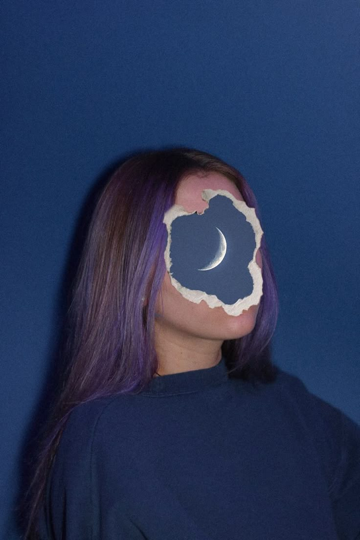 a woman with purple hair and a half moon on her face