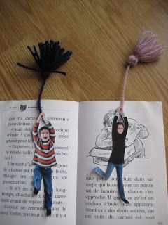 an open book with a paper doll hanging from it