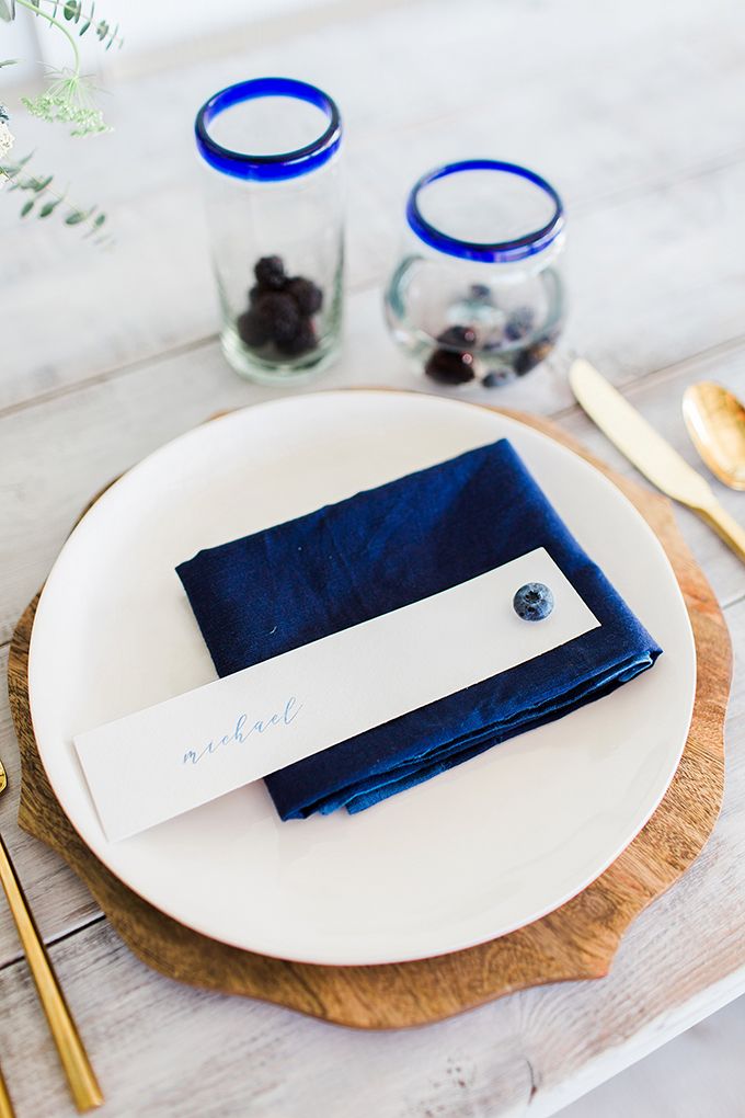 a place setting with blue napkins and silverware