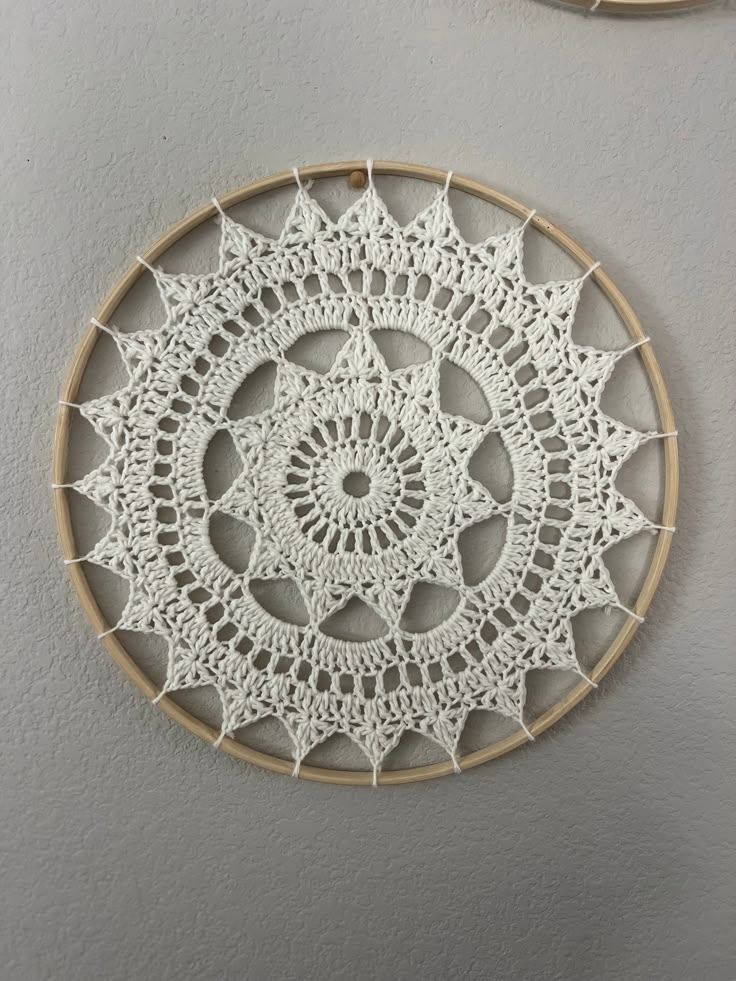 two circular crocheted doily hanging on the wall