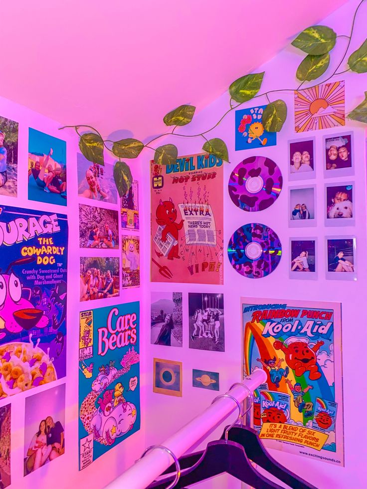 there are many posters on the wall in this kids's room with pink lighting