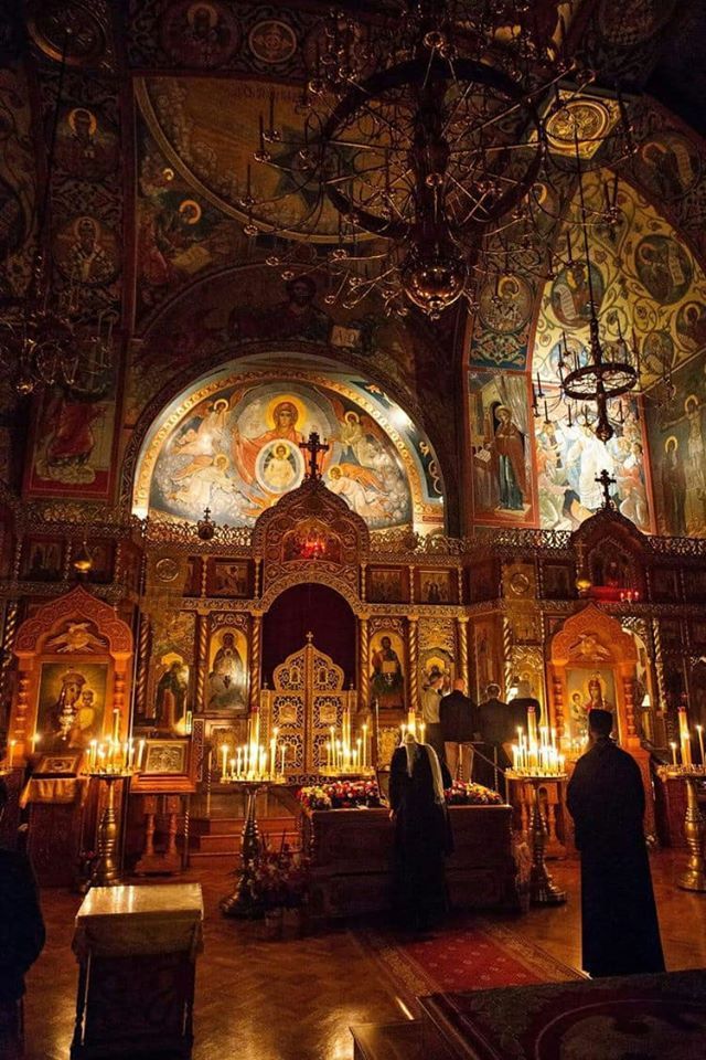 the interior of an old church with stained glass windows and chandeliers hanging from the ceiling