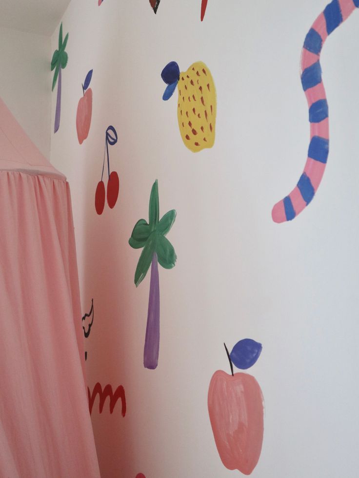 a child's room decorated in pink and blue with colorful wall decals on the walls