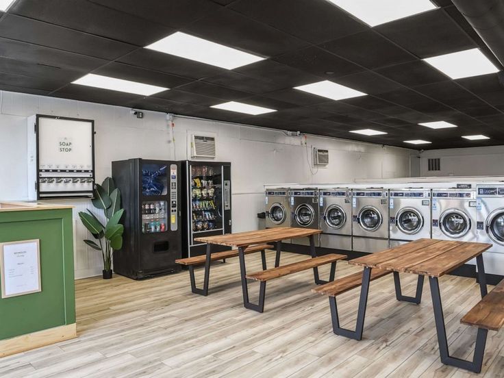 an empty laundry room with tables and washers