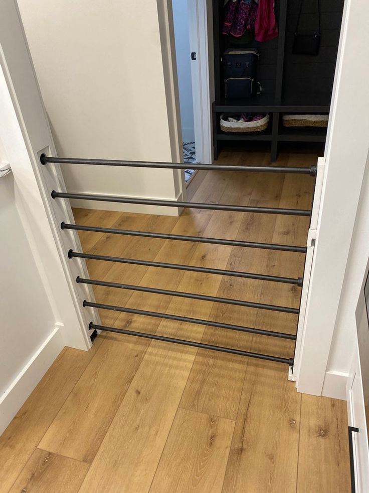 an open door leading to a hallway with wooden flooring and metal handrails