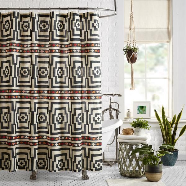 a bathroom with a shower curtain and potted plants on the floor next to it