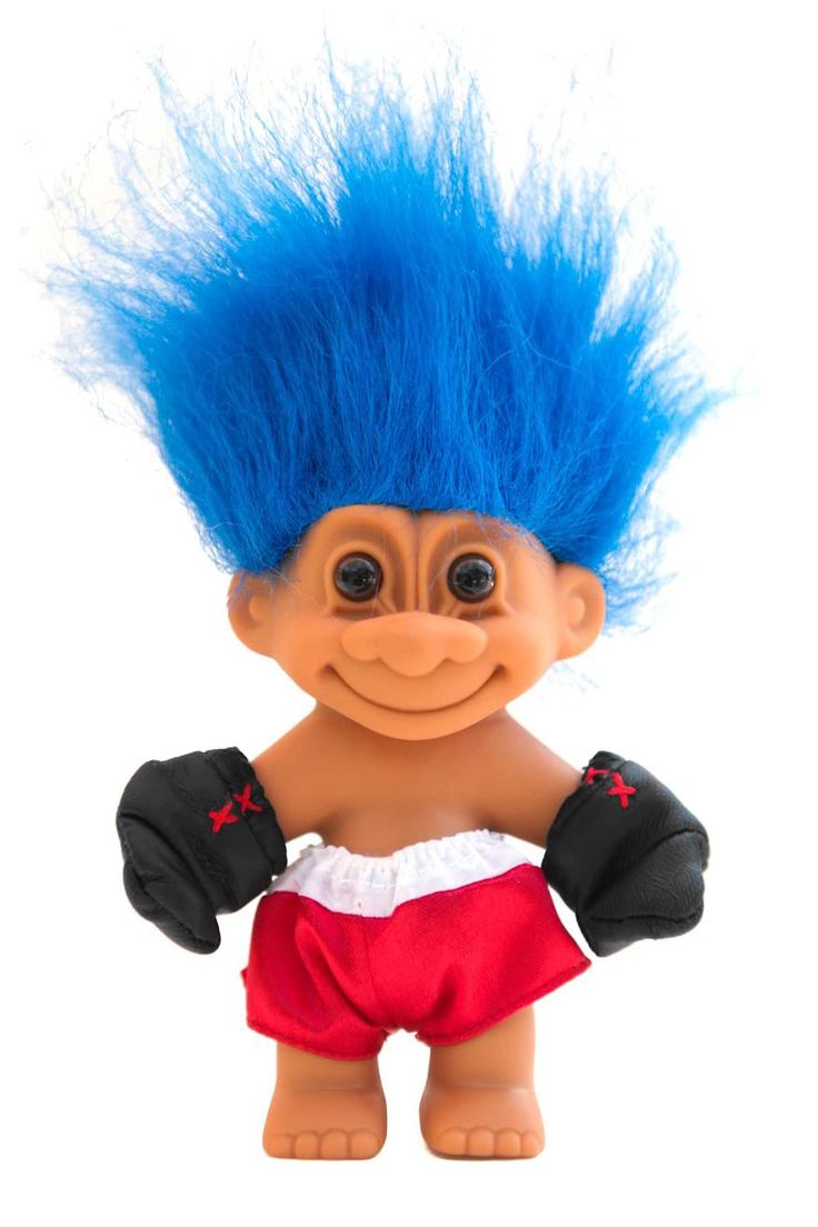 a troll doll with blue hair and red shorts