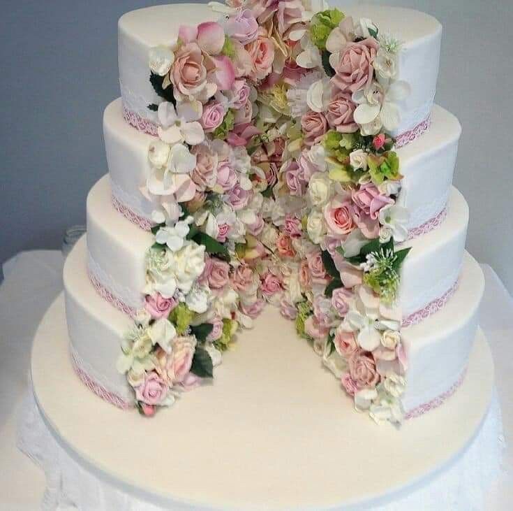 a white wedding cake with pink and green flowers on it's top tiers