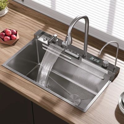 a stainless steel kitchen sink and faucet with water running from the faucet