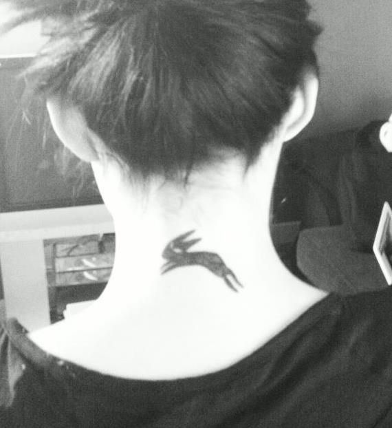 a woman with a bird tattoo on her neck