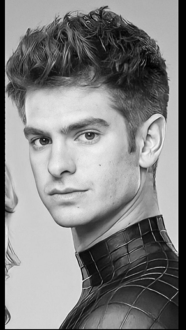 a black and white photo of a man in spider - man suit with his face close to the camera