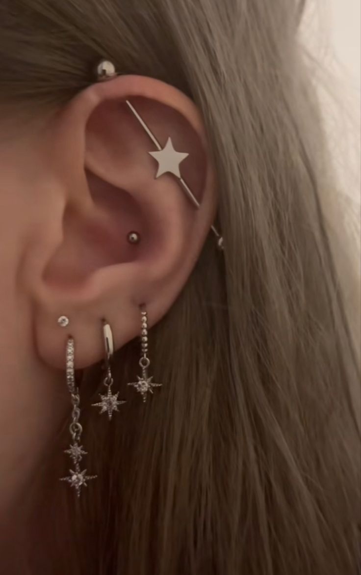 a woman wearing ear piercings with stars on them