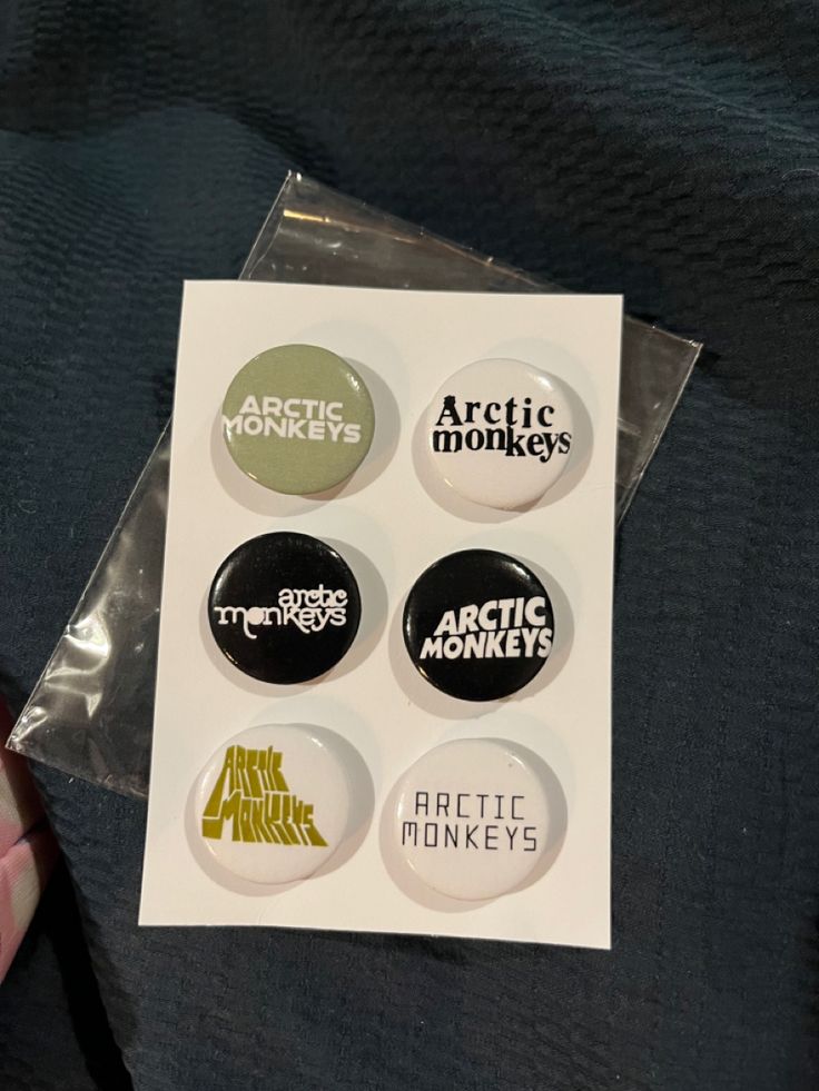 the arctic monkeys button set is on display in a plastic package with clear cellophane