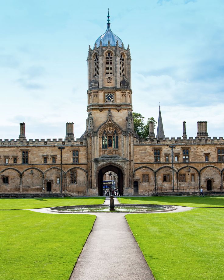 a large building with a clock tower on it's side and a walkway leading to the entrance