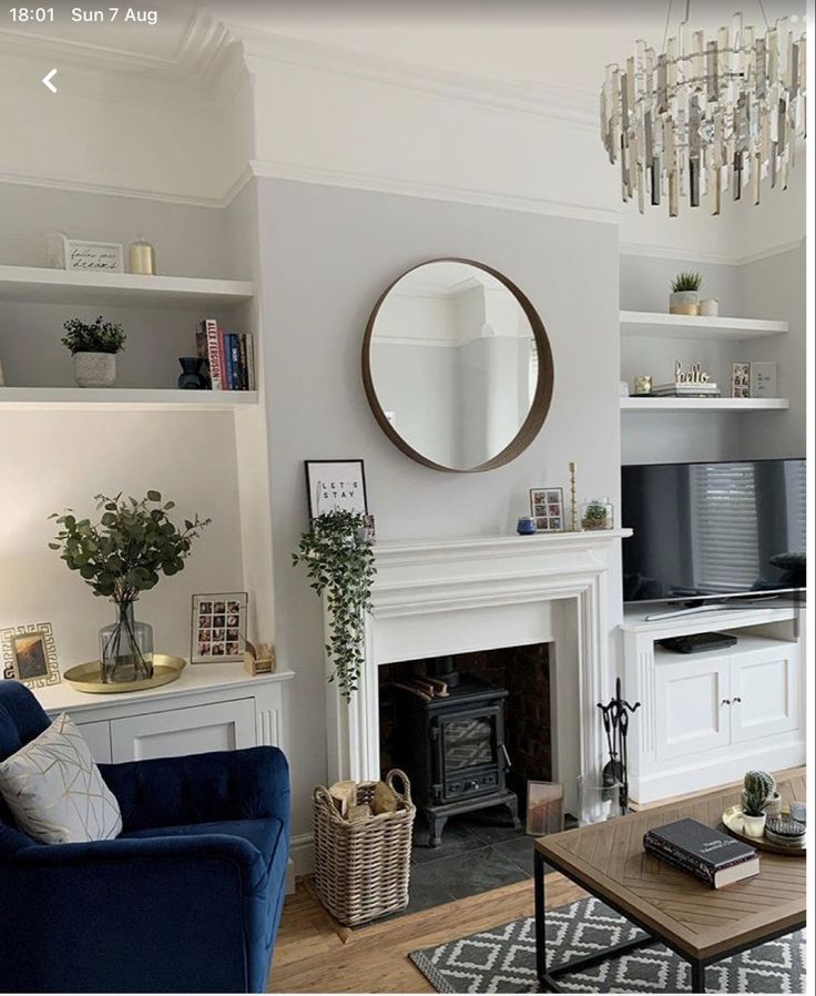 a living room filled with furniture and a fire place next to a tv mounted on a wall