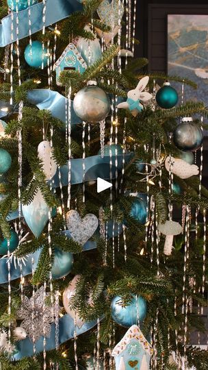 a christmas tree decorated with blue and silver ornaments