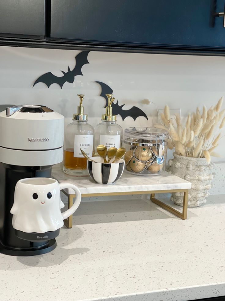 a coffee maker sitting on top of a counter next to a cup and some other items