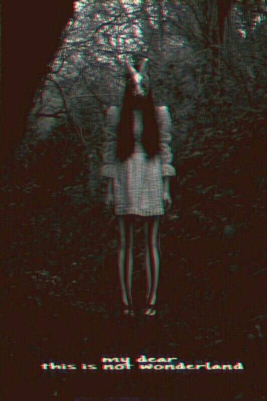 a girl standing in the woods with her arms around her head