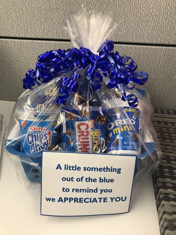 a basket filled with blue and white candies on top of a table next to a sign