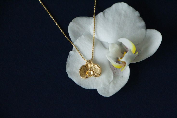 Orchid Flower 1 Micron 24K Gold Filled Sterling Silver Necklace, Floral Necklace, Bridal Necklace, Gift For Her, Gift Necklace, Romantic Necklace Material: Necklace is 1 micron 24K gold filled sterling silver. (Micron plating contains a much higher amount of gold compared to normal gold plating. Therefore, it can be used for many years without any deformation in its coating.) Necklace metal parts (sterling silver) are antiallergenic.  Care Instructions: It is recommended to keep it in its own box.  Silver parts may tarnish over long time, but can be easily cleaned with a soft jewelry cloth and/or tarnish remover. Shipping: Your jewels send with its special Alegoria Jewellery gift box.  Feel free to contact with us for any questions!  Also connect with us on social media: IG @alegoria.jewel Gold Flower Necklaces For Celebration, Orchid Necklace, Romantic Necklace, Minimal Necklace, Necklace Bridal, Floral Necklace, Orchid Flower, Bridal Necklace, Metal Necklaces