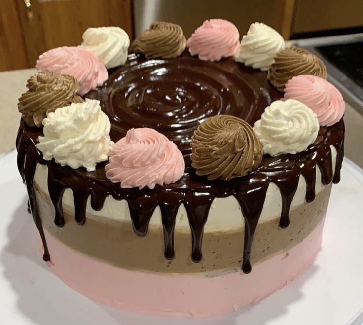 a chocolate cake with pink and white frosting