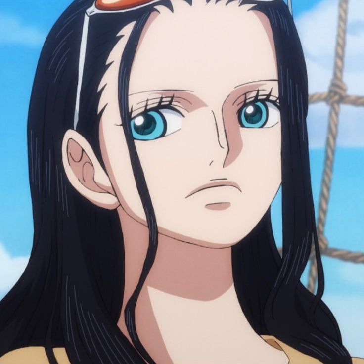 a woman with long black hair and blue eyes stares at the camera while standing in front of a ship