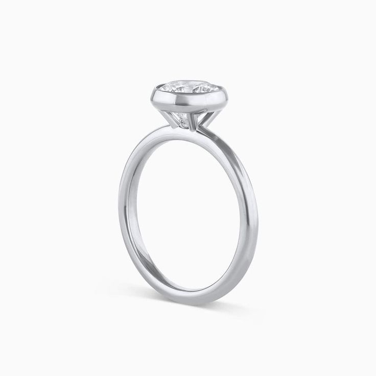 The Tulip Engagement Ring combines modern elegance and timeless design. This ring is a bezel setting that sits taller allowing for straight bands to sit flush. The Tulip Engagement Ring can be set with any size or shape of center stone and is available in 14k or 18k yellow gold, white gold, rose gold or platinum. The price listed includes the setting only. Want more info? Book an appointment to sit down with one of our bridal experts virtually or in-store. White Gold Asscher Cut Ring With Bezel Setting, White Gold Rings With Bezel Setting, Asscher Cut, Timeless Wedding Ring With Bezel Setting, Timeless Asscher Cut Diamond Ring With Bezel Setting, Timeless Formal Wedding Jewelry With Smooth Bezel, Modern Stackable Rings With Tension Setting For Anniversary, Timeless Solitaire Halo Ring With Round Band, Timeless Solitaire Stackable Rings, Elegant Anniversary Ring With Smooth Bezel