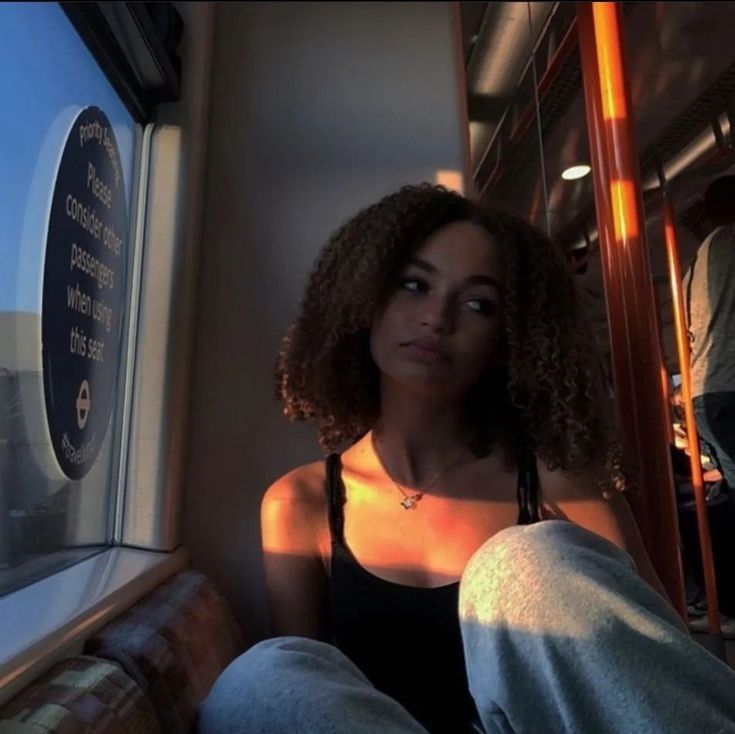 a woman sitting on a train looking out the window