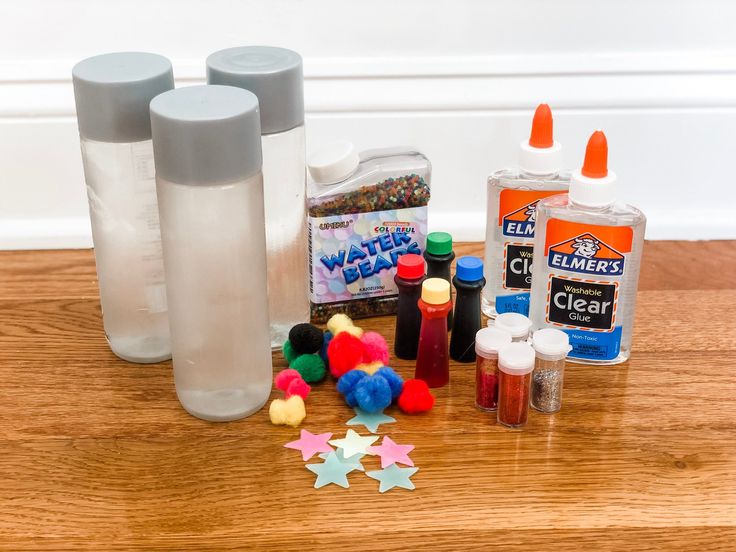 various crafting supplies sitting on a table with glue and star shaped objects next to them