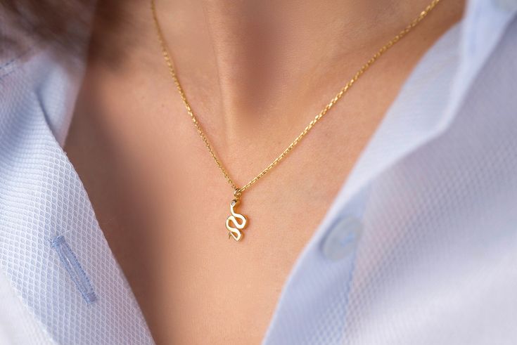 Our snake pendant necklace is made of 14k solid gold. It has a minimalist style that everyone loves it! Our snake's eye consists of zircon stone that looks charming. When you consider our gold snake necklace as a gift, it will make your loved ones happy on their birthday, mother's day, valentine's day, anniversaries, graduations, Christmas, or women's day. 🐍 🎁 If you want, you can add a gift note for your loved ones. It arrives in a special jewelry gift box. ✨ We respond to your questions happily. Your question will be answered within 24 hours. Do not hesitate to contact us. 💎 I hope you have a lot of Onseva's designs. :) (If you want to buy no chain, we suggest that you should pay attention to the closure size of your chain.) a.b.-G Minimalist Snake Chain Charm Necklaces As Gift, Dainty Snake Shape Necklace For Gift, Dainty Snake-shaped Necklace For Gift, Minimalist Yellow Gold Snake-shaped Necklace, Gold Snake Necklace, Serpent Necklace, Snake Gift, Small Snake, Small Snakes