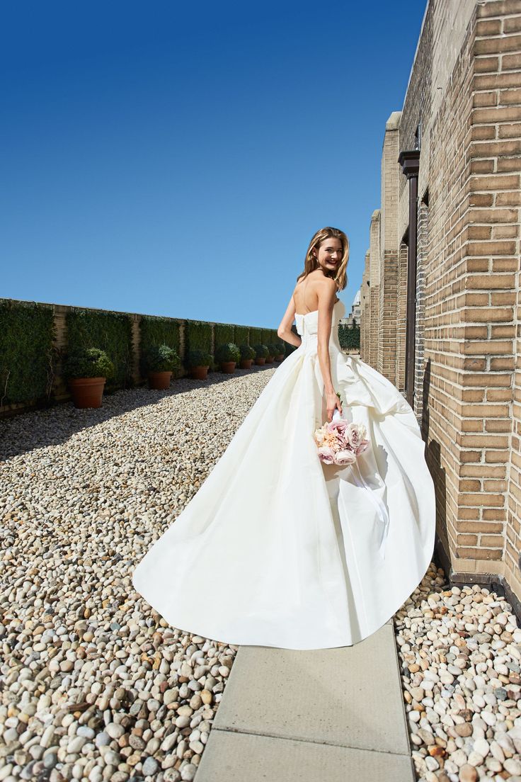 a woman in a wedding dress is walking down the street