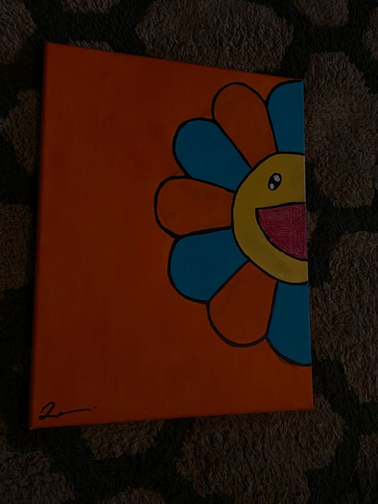 an orange and blue flower is on the floor