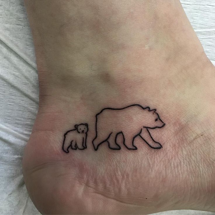 a small bear and cub tattoo on the foot