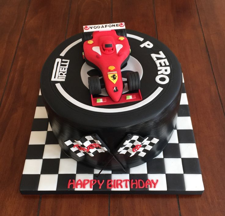 a birthday cake that is shaped like a race car on top of a checkered board