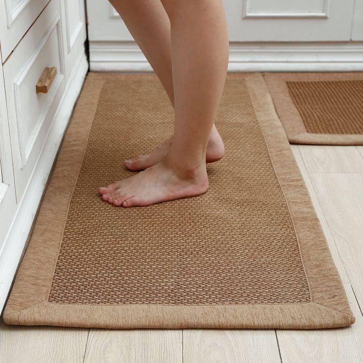 a person standing on a mat in the kitchen