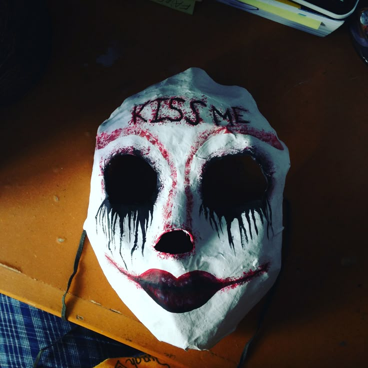 a paper mache mask with the words kiss me painted on it