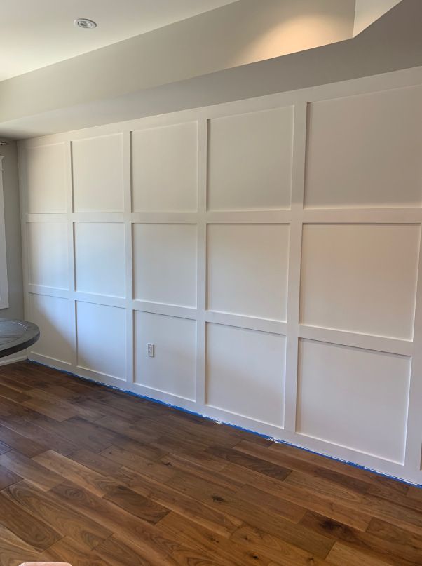 an empty room with hard wood floors and white paneling on the walls is shown