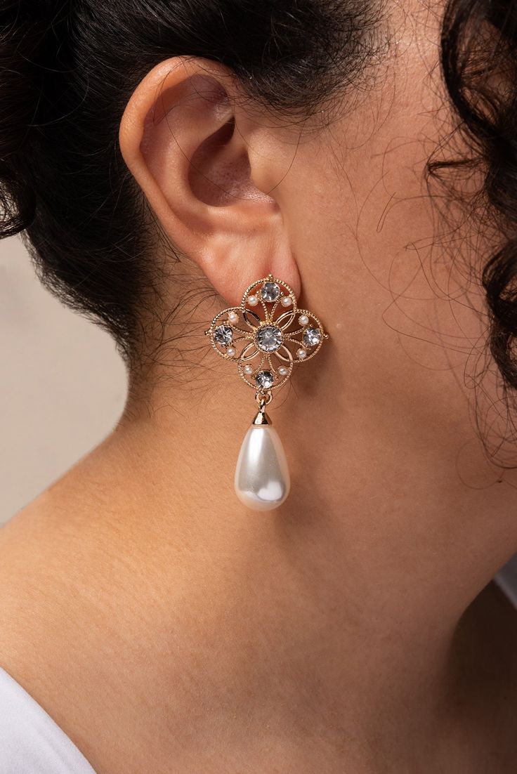 Are you someone that likes flowers, pearls, and jewelry? Then you've come to the right place! Our Metal Flower Pearl Drop earrings are the perfect combination of all those things, and they're made to impress! Perfect for all occasions, both formal and casual. Size Length: 2.25 in (5.72 cm)Width: 1.1 in (2.79 cm) QualityThese earrings are made of metal alloy with acrylic pearls and rhinestones placed all around the earring. They are fastened with a post backing mechanism. Imported EQ300 Elegant Bridal Earrings With Pearl Drop In Flower Shape, Feminine Pearl Drop Flower Earrings For Formal Occasions, Elegant Flower Shaped Earrings With Pearl Drop, Pearl Drop Bridal Earrings In Flower Shape For Party, Party Bridal Earrings With Pearl Drop In Flower Shape, Elegant Pearl Flower Earrings For Formal Occasions, Elegant Pearl Drop Flower Earrings For Party, Party Jewelry With Pearl Drop In Flower Shape, Formal Flower Shaped Pearl Drop Jewelry