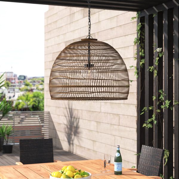 a wooden table topped with fruit under a hanging light over an outdoor dining room area