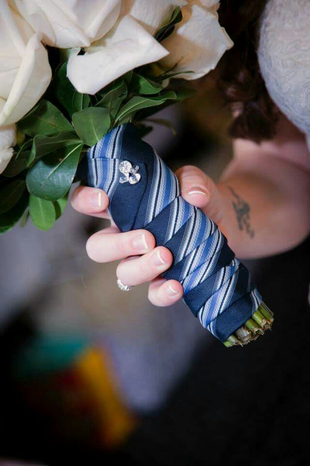 a woman holding a bouquet of white roses and an umbrella wrapped in blue fabric with the word love written on it