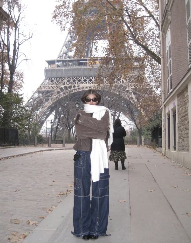 a woman standing in front of the eiffel tower