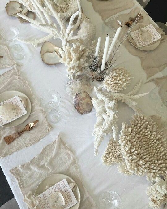 the table is set with shells and candles