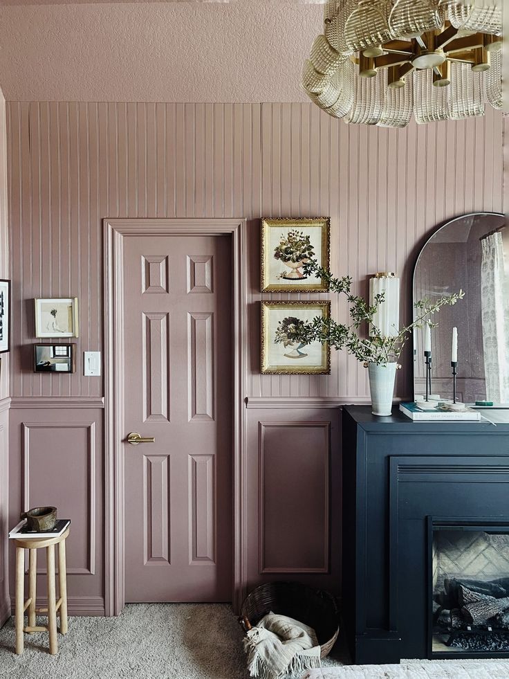 a living room with pink walls and white carpeted flooring next to a fireplace