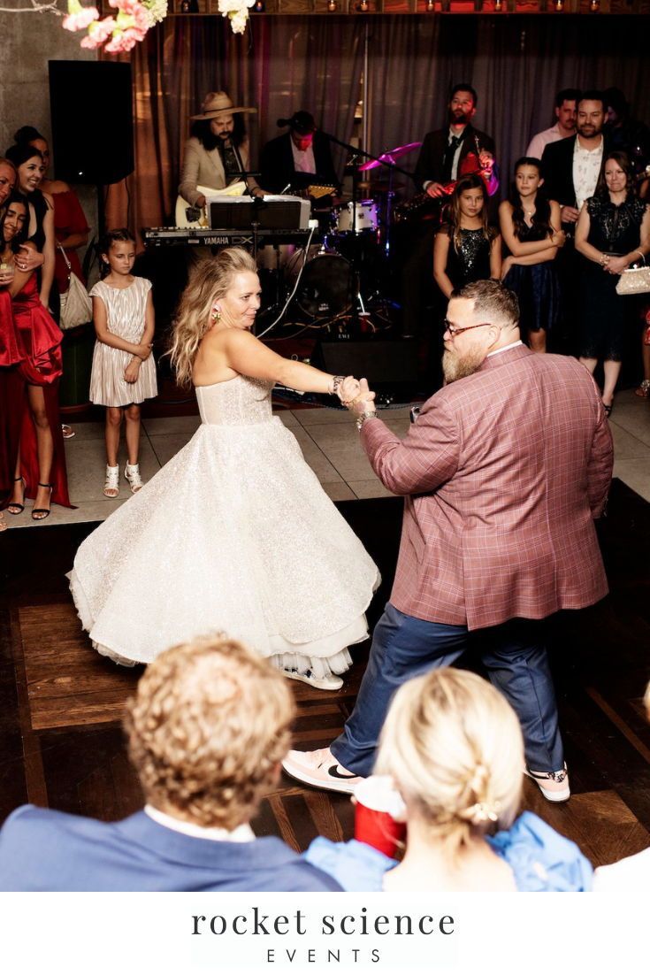 a bride and groom dancing on the dance floor at their wedding reception in front of an audience