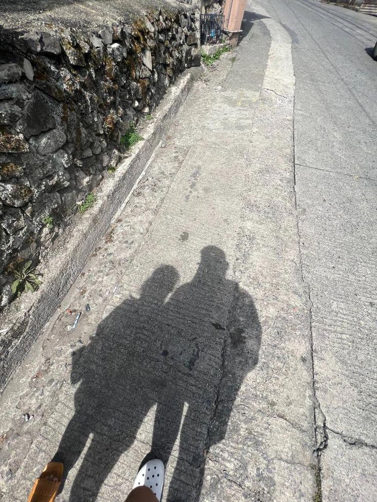 the shadow of two people standing next to each other