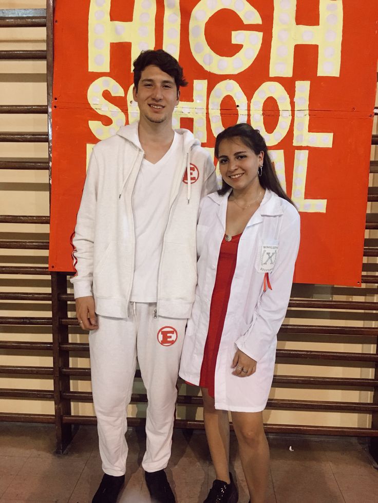 two people standing next to each other in front of a sign that says high school