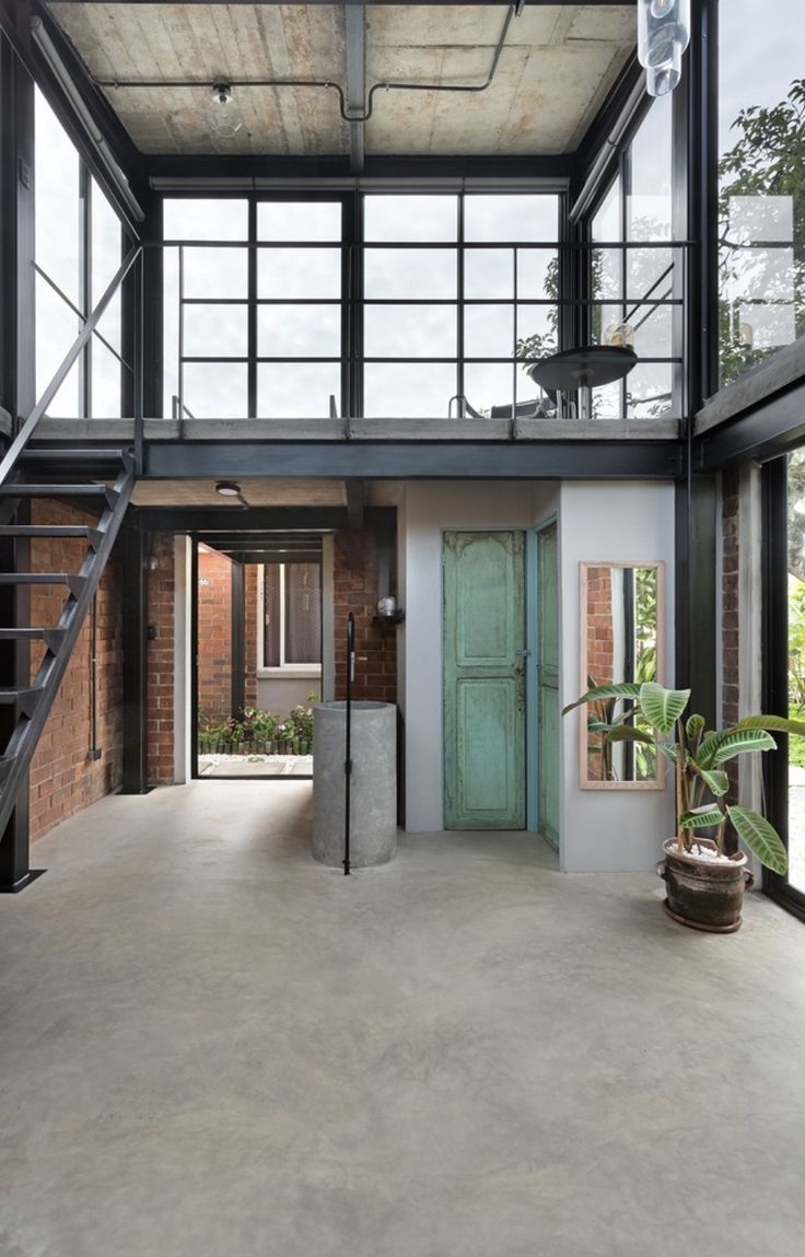 the inside of a building with stairs leading up to an open door and two planters