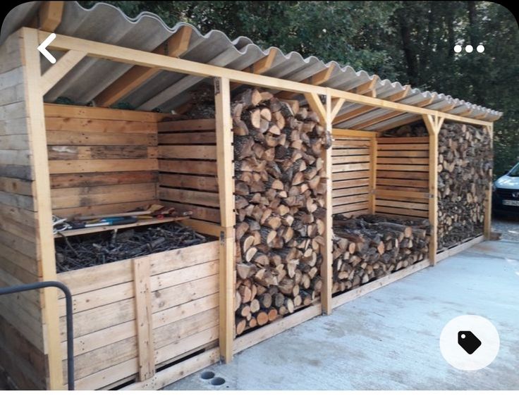 a building made out of wood with logs stacked on top of each other in front of it